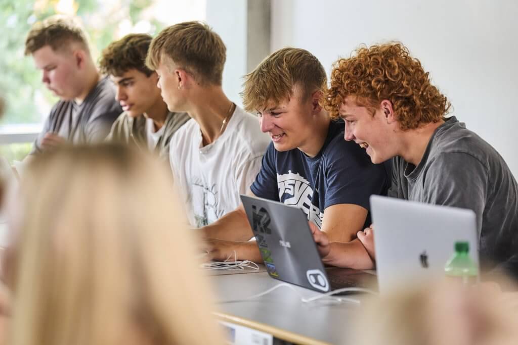 5 drenge sidder foran deres computere til undervisning på Campus Vejle